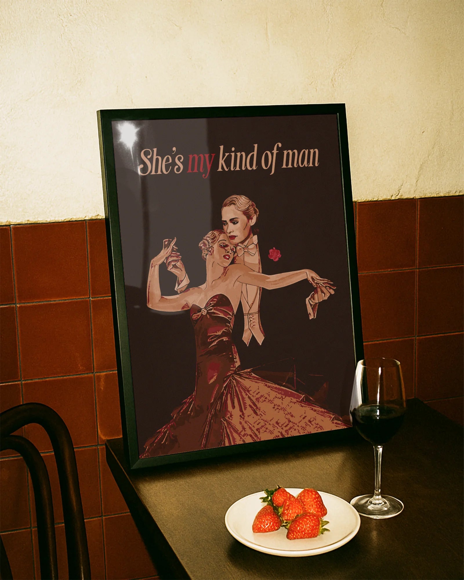 A framed print featuring a queer dancing couple in a vintage style, with the text: “She's my kind of man.”