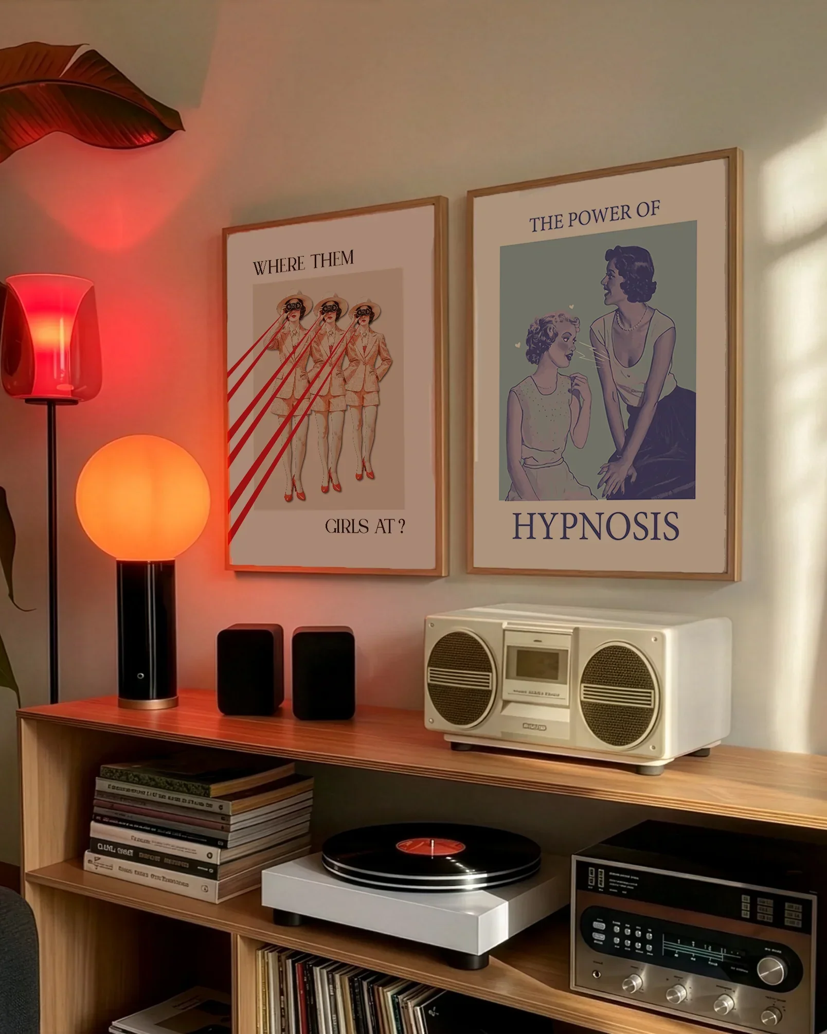 A gallery wall with several framed, queer posters in a living room.