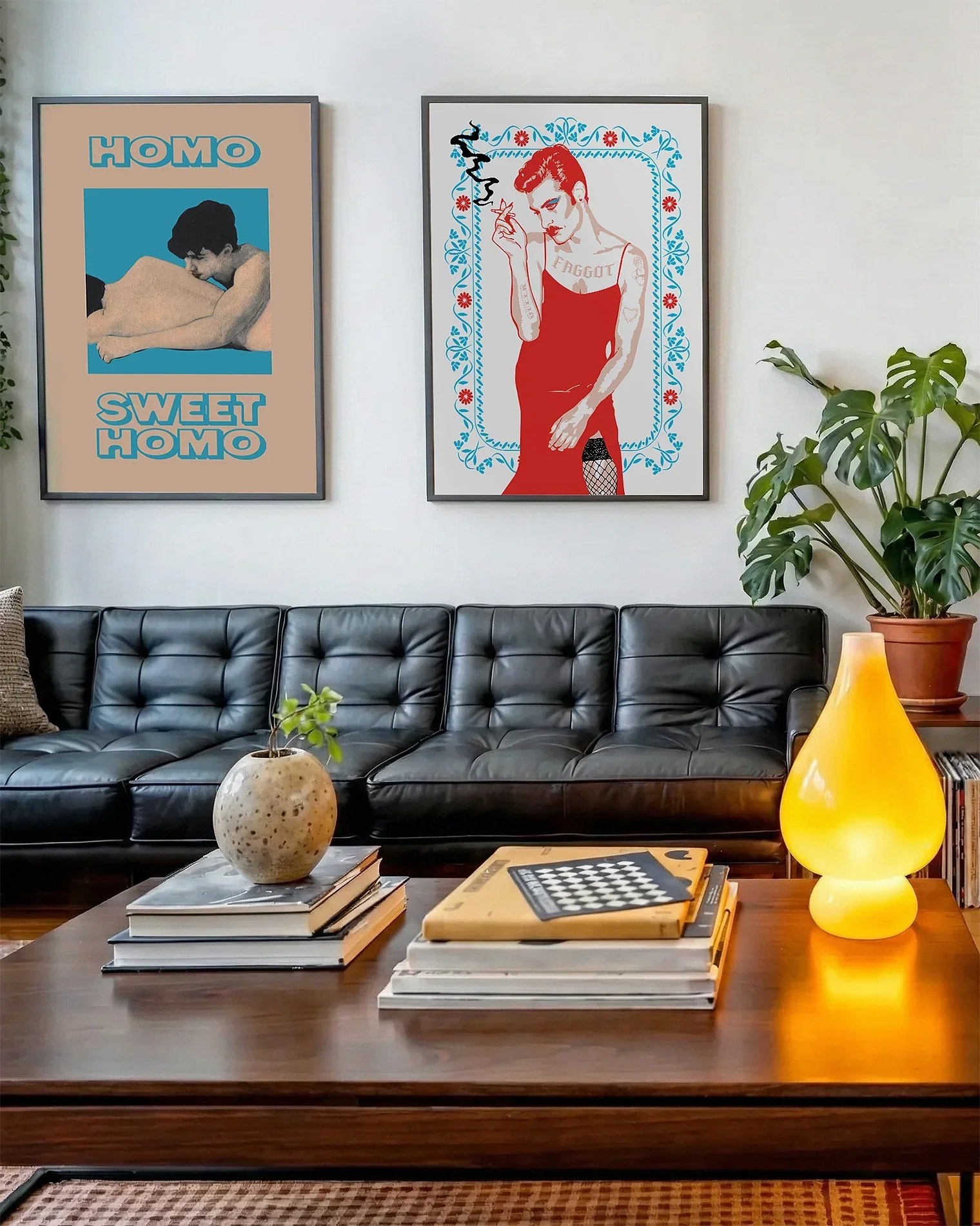A gallery wall with several framed, queer posters in a living room.