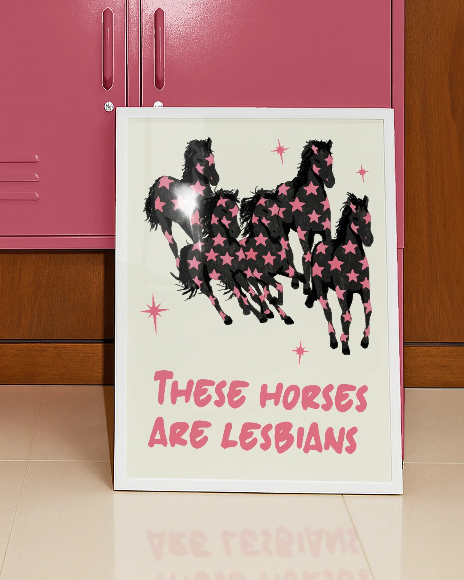 A framed poster with five horses and the text 'THESE HORSES ARE LESBIANS'.