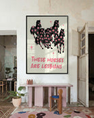 A framed poster with five horses and the text 'THESE HORSES ARE LESBIANS'.